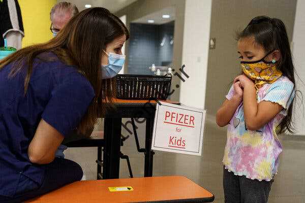 میلا پاگادور، 5 ساله، قبل از دریافت دوز خود از واکسن Pfizer-BioNTech Covid-19 در Albuquerque، NM، با پرستار ثبت نام شده اشلی بین صحبت می کند.