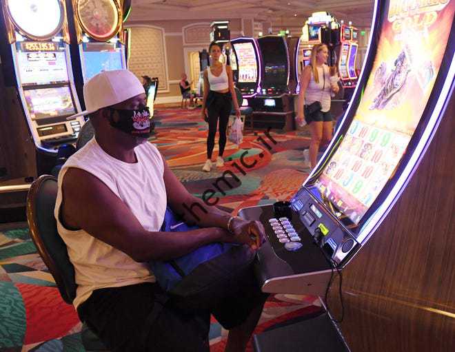 وین راجرز از تگزاس در 4 ژوئن 2020 در حالی که در Bellagio Resort & Casino در لاس‌وگاس استریپ در حال بازی با ماشین بازی می‌باشد، ماسک می‌زند.