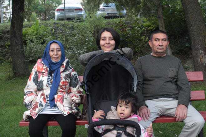 فاطمه حسینی مرکز و مادرش معصومه;  پدر، سید امین;  و خواهر کوچکتر مبینا پس از اینکه پس از فرار از افغانستان به سلامت به یکدیگر پیوستند، از پارکی در کیف اوکراین بازدید می کنند.